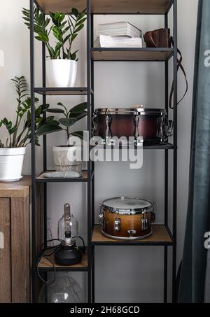 Drums, percussion instruments on the shelves in the interior of the room. Stock Photo