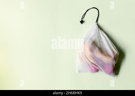 White reusable shopping bag on a light background with an insert on the left.  Stock Photo