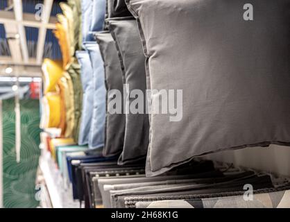Textile pillows of different colors on the counter in the store. Stock Photo