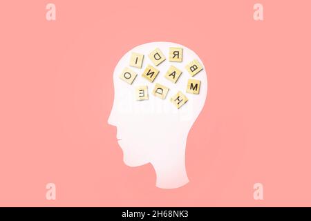 Dementia, alzheimer, memory and mental brain health concept background. Paper head with puzzle pieces on a pink background. High quality photo