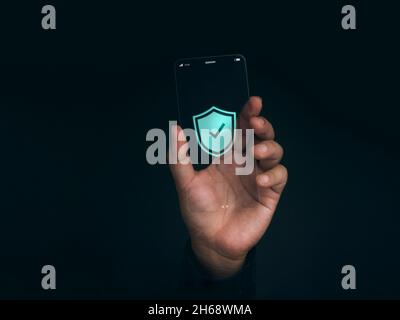 Security data technology and personal privacy on future phone concept. Shield with checkmark icon on the thin screen of futuristic transparent super s Stock Photo