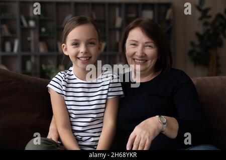 Head shot portrait smiling grandmother with granddaughter making video call Stock Photo