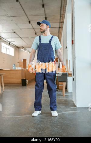 Bearded male worker holding plastic box with tools Stock Photo