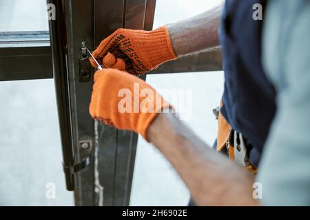 Male worker hands repairing door lock in house Stock Photo