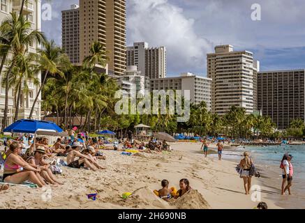 Waikiki, Honolulu, Hawaii - Oct 31, 2021-families enjoying the beach in front of high rise hotels. Stock Photo
