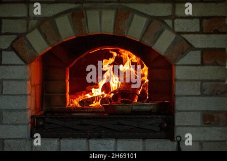 Burning log of wood in a fireplace close-up in a Barbecue. Stock Photo