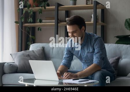 Happy handsome young businessman working on computer. Stock Photo