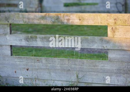 Simple wooden fence along a green lawn. Stock Photo