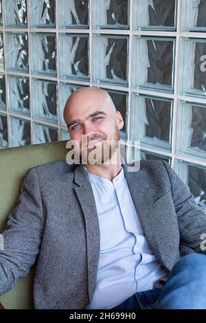 Portrait of white european bald man with beard and grey eyes in suit jacket Stock Photo