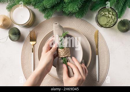 Woman preparing festive place setting for Christmas dinner Stock Photo