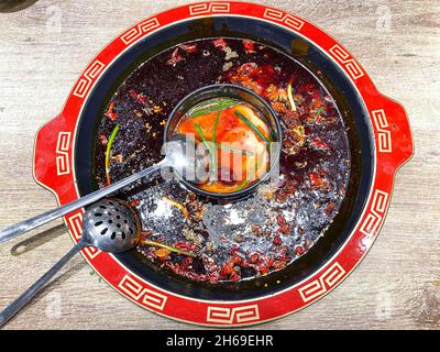 Sichuan Hotpot with Spicy chilli peppers on the outside and tomato soup on the inside Stock Photo