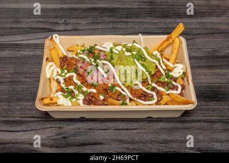 Shredded Beef Fries, Guacamole Paste and Red Bean Chili Pepper with Cream Cheese and Mayonnaise Sauce in Home Delivery Container Stock Photo