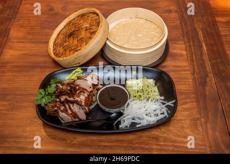 Chinese Recipe for Chopped Roasted Pekin Duck with Sauce, Onion, Cucumber Strips, and Steamed Rice Tortillas Stock Photo