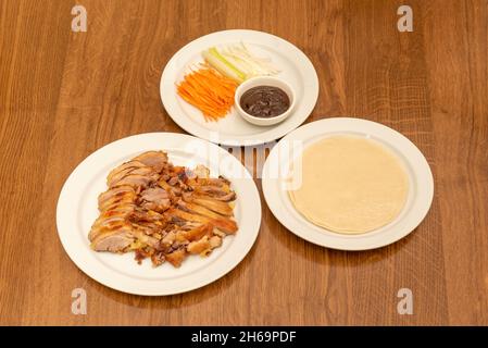 Chinese Recipe of Chopped Roasted Peking Duck with Sauce, Onion, Cucumber Strips and Carrots with Steamed Rice Tortillas Stock Photo