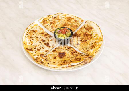 The quesadilla consists of a corn or wheat tortilla, folded in half that can be filled with cheese, beans and chicken and eaten hot, either fried or c Stock Photo