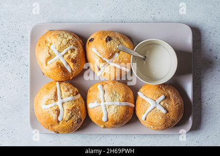 Traditional Easter cross buns with raisins on gray plate, top view. Stock Photo