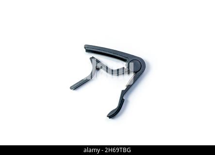 Matte black capo for acoustic and classical guitar isolated on white background. Stock Photo