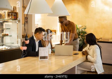 Business team watching something on laptop in cafe Stock Photo