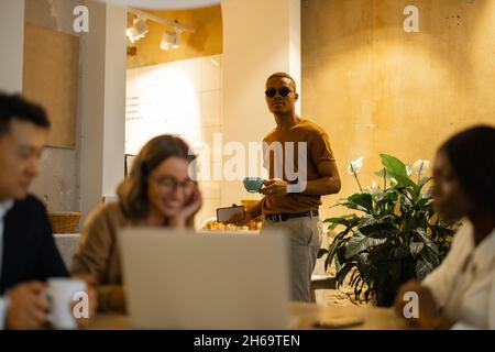 Business team watching something on laptop in cafe Stock Photo