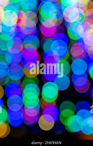 Colored blurred lights, defocused background. New Year Christmas background with multicolored blurred lights. Stock Photo