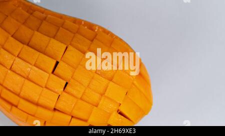 Mango slice cut to cubes close-up isolated on light grey background Stock Photo