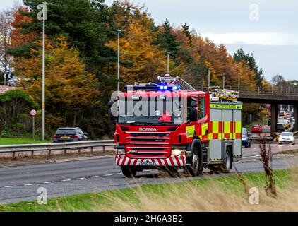 A Scottish Fire and Rescue Service fire engine responds to an emergency 999 call at high speed along the Kingsway West Dual Carriageway in Dundee, UK Stock Photo