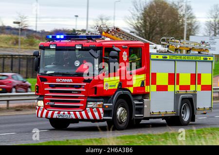 A Scottish Fire and Rescue Service fire engine responds to an emergency 999 call at high speed along the Kingsway West Dual Carriageway in Dundee, UK Stock Photo