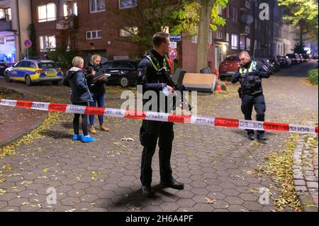Hamburg, Germany. 14th Nov, 2021. A police officer with a submachine gun secures a cordoned-off crime scene. Shots were reported in Hamburg-Harburg on Sunday afternoon. Two people were possibly injured, said an employee at the police situation service. Credit: Jonas Walzberg/dpa/Alamy Live News Stock Photo
