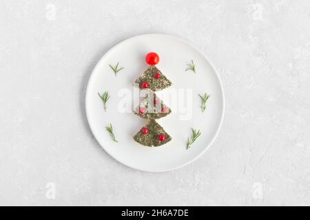 new year tree made of cheese and decorated with red currant and cherry tomatoes, decoration for new year table, white plate, top view Stock Photo