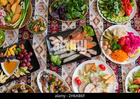 Ukrainian and Russian cuisine assorted salads with vegetables in plates with bacon and onions with assorted cheeses Stock Photo