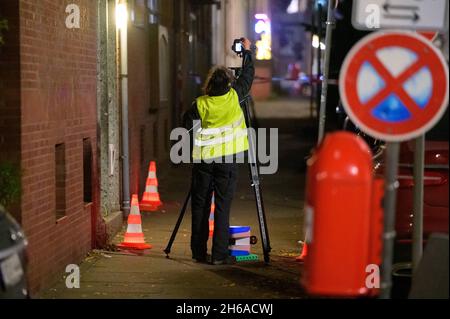 Hamburg, Germany. 14th Nov, 2021. A forensic scientist scans the cordoned-off crime scene. Shots were reported in Hamburg-Harburg on Sunday afternoon. Two people may have been injured, said an official at the police situation service. Credit: Jonas Walzberg/dpa/Alamy Live News Stock Photo