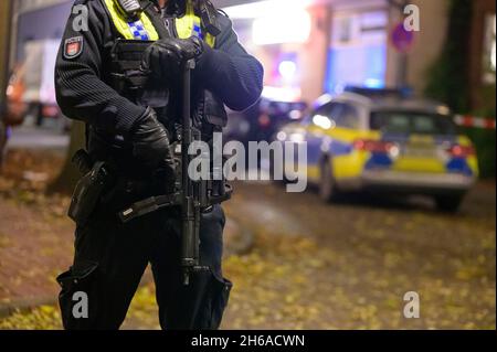 Hamburg, Germany. 14th Nov, 2021. A police officer with a submachine gun secures a cordoned-off crime scene. Shots were reported in Hamburg-Harburg on Sunday afternoon. Two people may have been injured, said an official at the police situation service. Credit: Jonas Walzberg/dpa/Alamy Live News Stock Photo