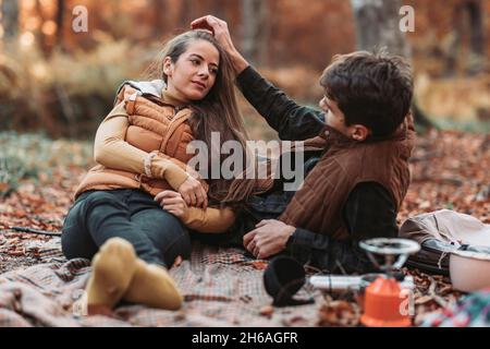 Romantic couple having a picnic in the woods. Autumn vibes Stock Photo