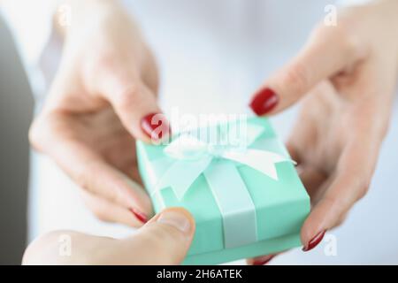 In woman hands is small turquoise gift box with bow Stock Photo