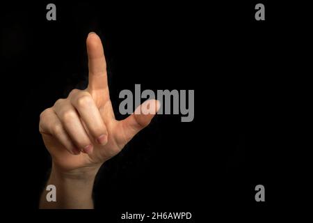 Businesswoman hand pointing on empty space on a black background Stock Photo