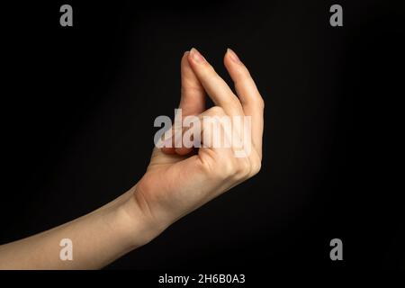 Hand gesture snapping fingers, easy sign and symbol on a black background photo Stock Photo