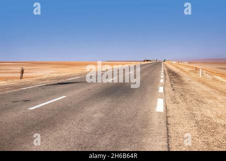An asphalt road that runs along the Sahara Desert. Sahara Desert, Tunisia Stock Photo
