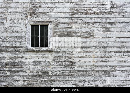 Window on weathered wooden exterior wall of a barn Stock Photo