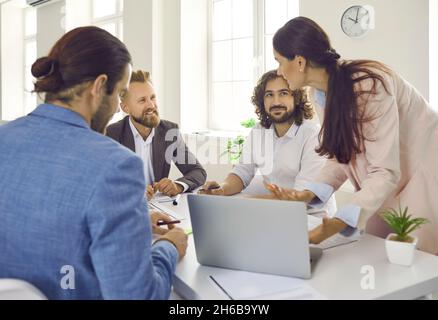 Team of young corporate employees talking during a meeting around an office table Stock Photo