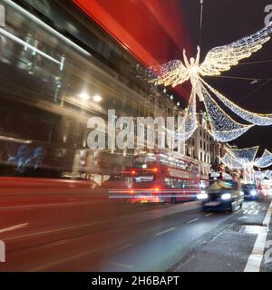 London, Greater London, England, November 13 2021: Spirit of Christmas festive light display on Regent Street at night as traffic whizzes by. Stock Photo