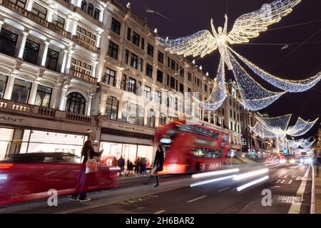 London, Greater London, England, November 13 2021: Spirit of Christmas festive light display on Regent Street at night as traffic whizzes by. Stock Photo