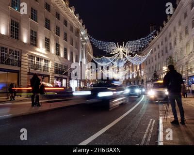 Spirit of Christmas festive light display on Regent Street at night as traffic whizzes by and photographers try to capture the scene. Stock Photo