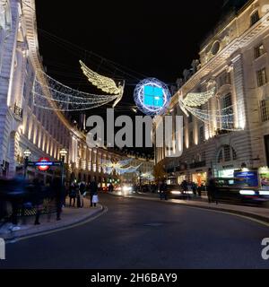 London, Greater London, England, November 13 2021: Spirit of Christmas festive light display on Regent Street at night as traffic passes beneath. Stock Photo