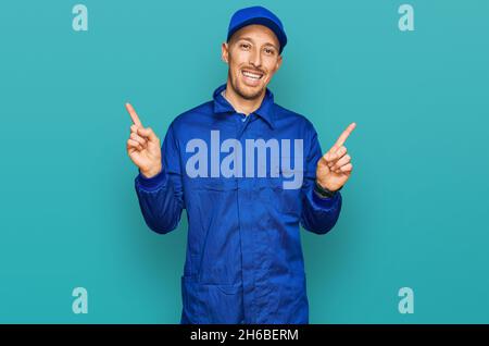 Bald man with beard wearing builder jumpsuit uniform smiling confident pointing with fingers to different directions. copy space for advertisement Stock Photo