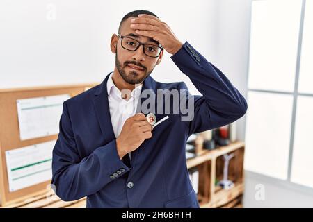 African american young man putting virtual currency bitcoin in the pocket stressed and frustrated with hand on head, surprised and angry face Stock Photo