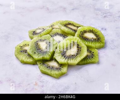 Slices of peeled kiwi on a marble surface Stock Photo