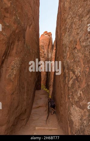 Person fooling around in a narrow gorge in the Arches National Park, USA Stock Photo