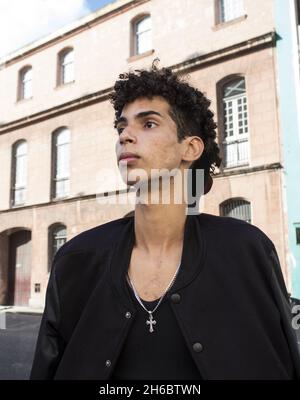 A young curly-haired Hispanic male in the streets of Old Havana, Cuba Stock Photo