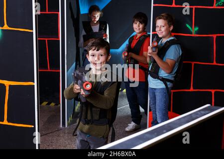 boy aiming laser gun at other players during lasertag game Stock Photo