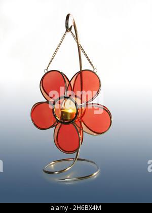 A lamp with the shape of a flower and a candle inside isolated on a gradient white and blue background Stock Photo